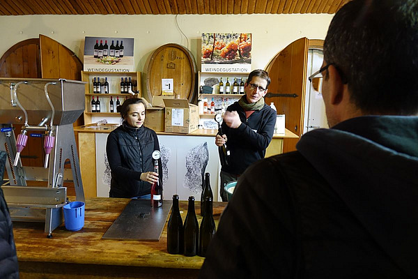 Sektkurs FiBL Zwei Personen stehen an einem Tisch, auf welchem Sektflaschen herumstehen.