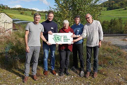 Fünf Personen halten ein Schild mit der Aufschrift "Swiss Plant Breeding Center".