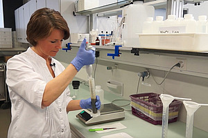 Parasitenbefall beim Tier bestimmen Person im Labor mit Pipette.