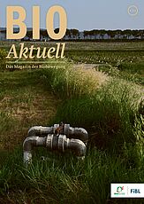 Titelseite Bioaktuell 6|24: Ein Feld mit zwei Wasserrohren, die aus der Erde ragen.