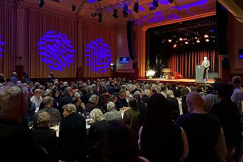 Une salle pleine avec un orateur.