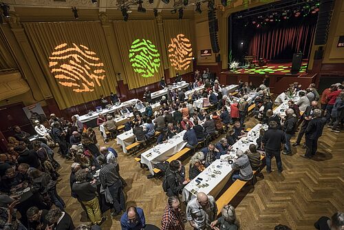 Ein gut besetzter Festsaal von oben.