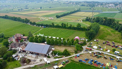 Eine Luftaufnahme eines Landwirtschaftsbetriebs mit Maschinenausstellung.